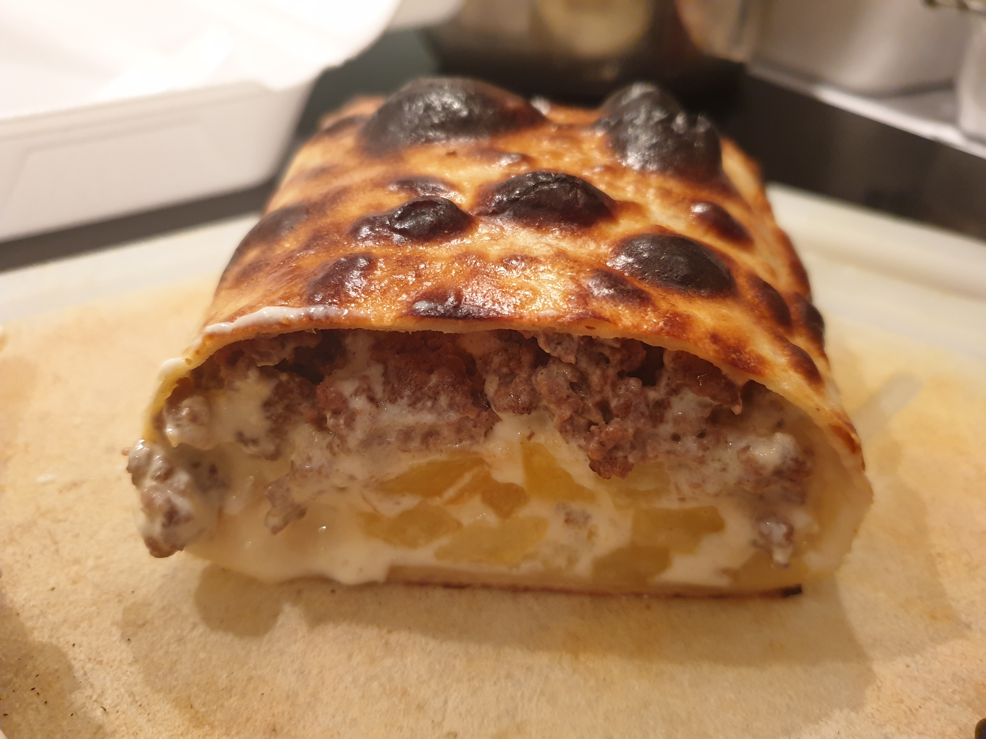 Calzone gratiné au fromage et viande hachée coupé en deux