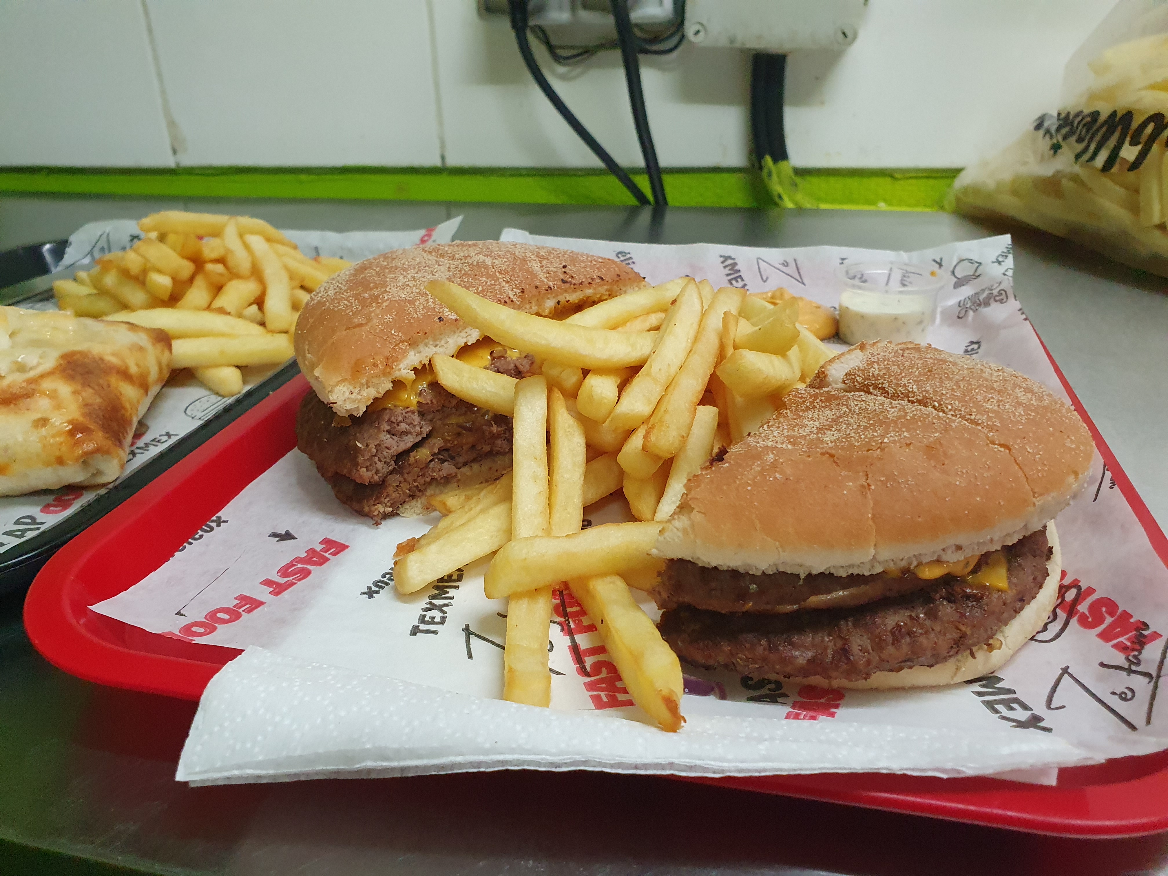 Deux cheeseburgers avec frites sur plateau chez ZAKI FOOD