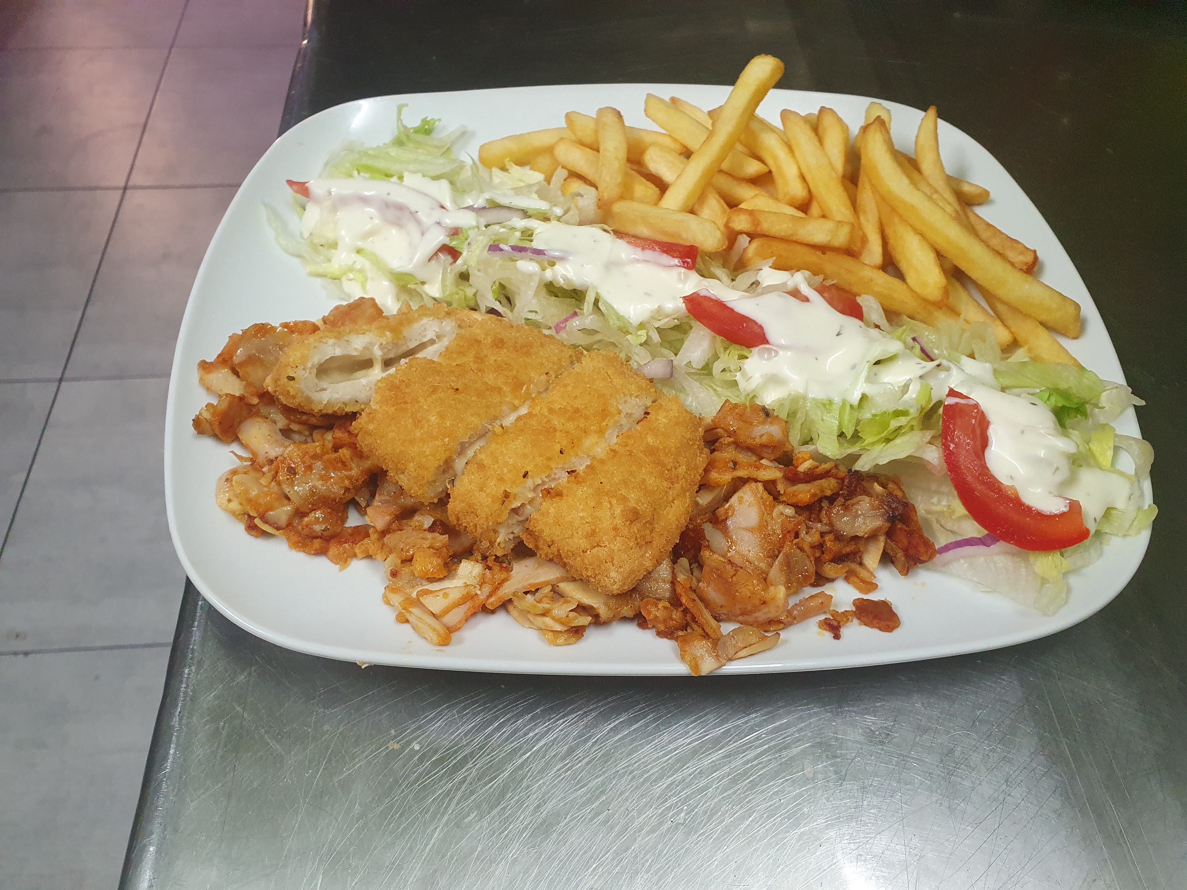 Assiette de viande kebab avec cordons bleus panés, frites et salade