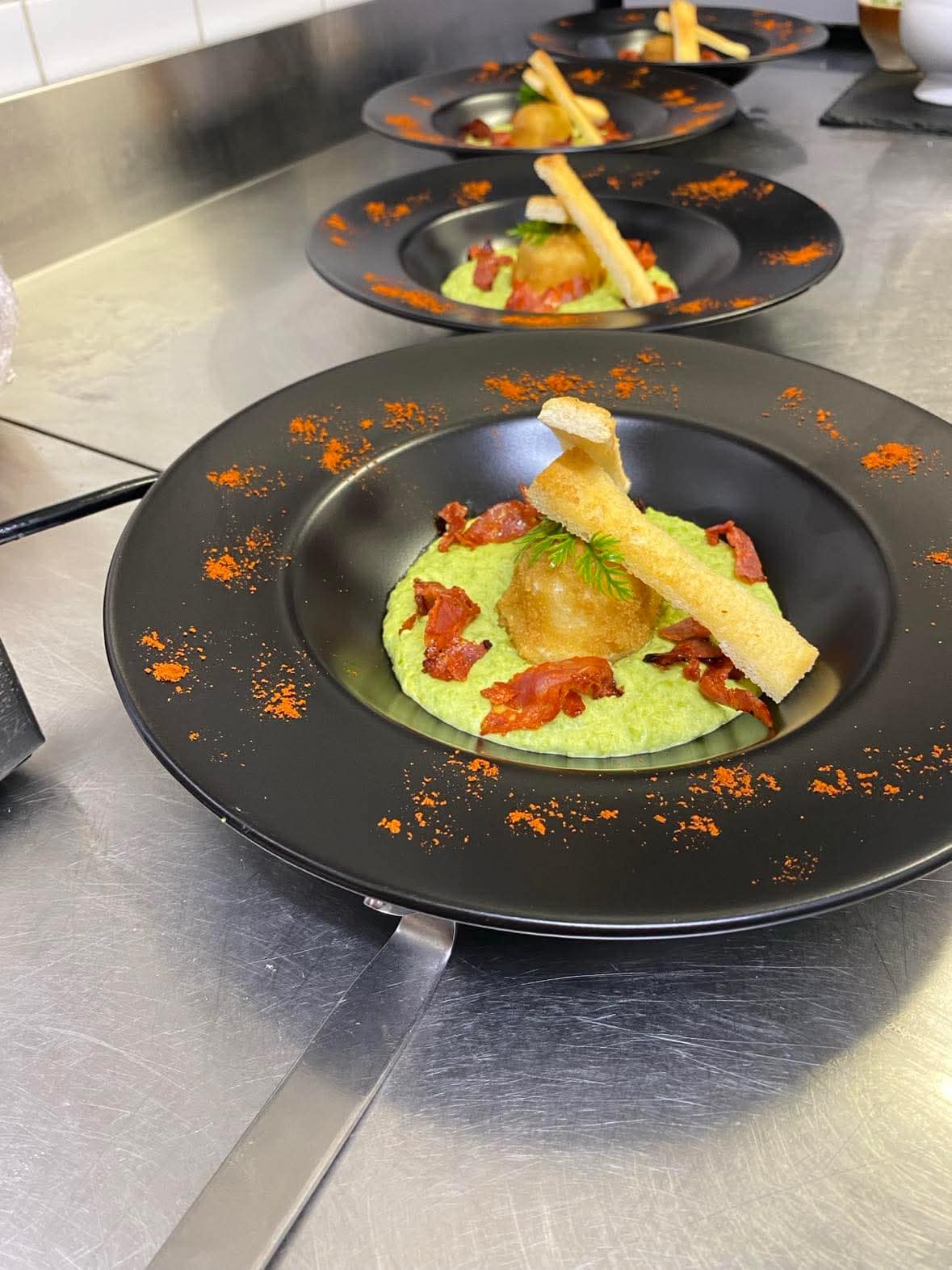 Entrée gastronomique sur crème de petits pois, chips de jambon cru et tuile croustillante