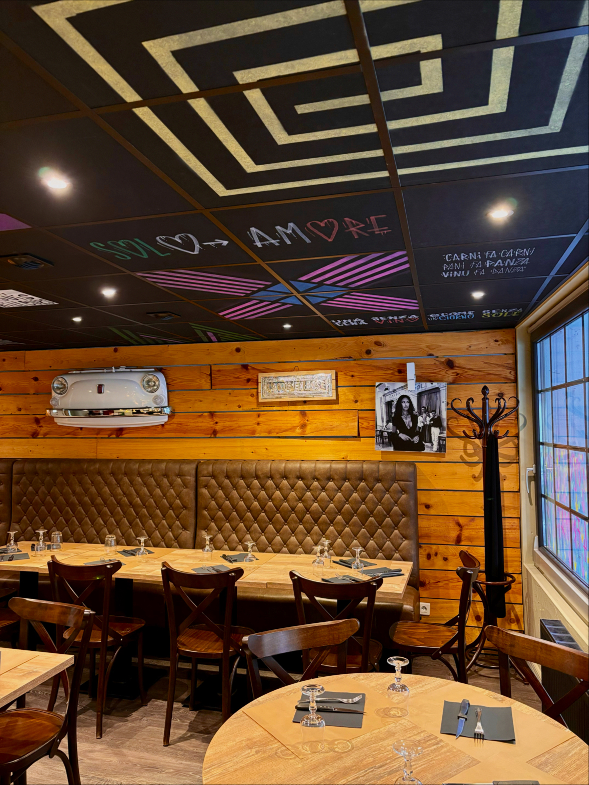 Salle du restaurant avec plafond artistique, ambiance Solo Amore et tables dressées