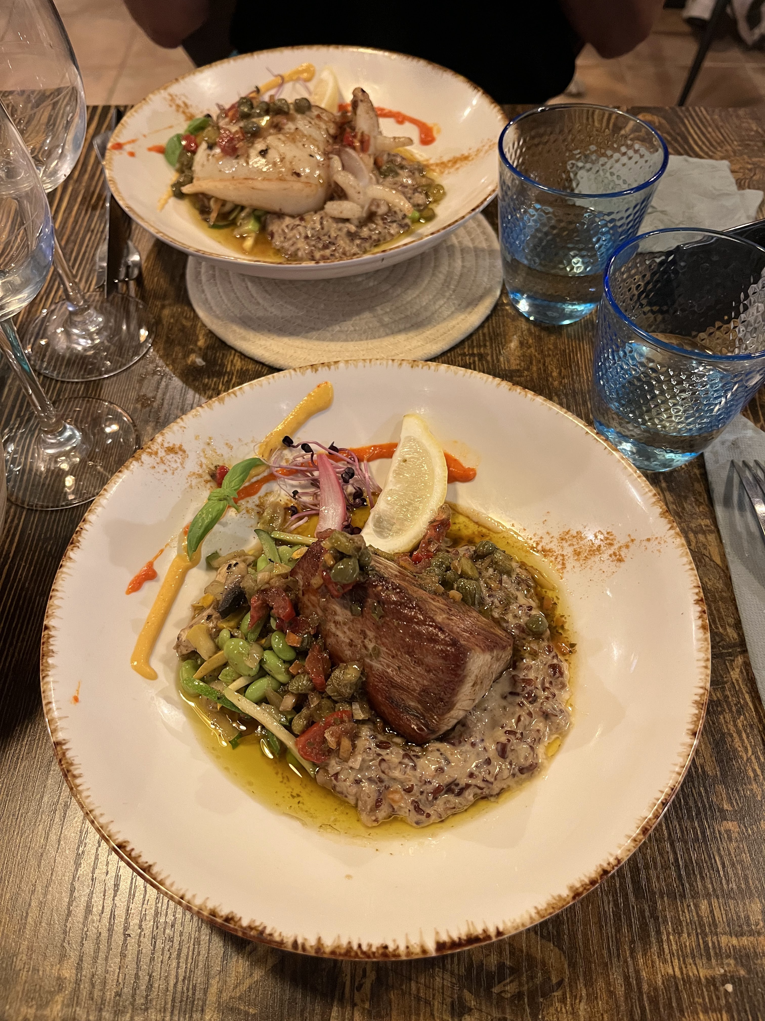 Plat de viande sur lit de risotto avec légumes de saison et jus réduit