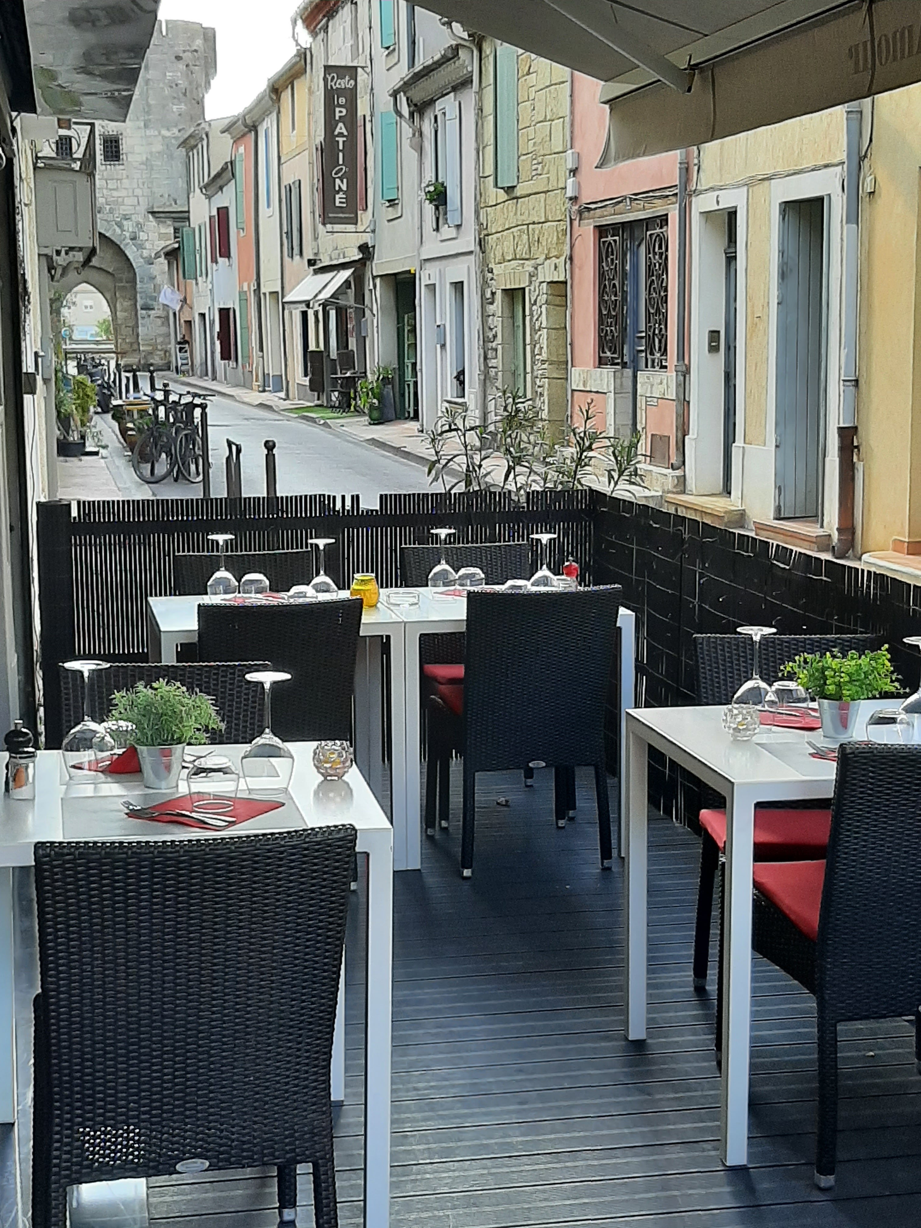 Terrasse du restaurant Le Saint Amour avec tables dressées dans une rue d'Aigues-Mortes