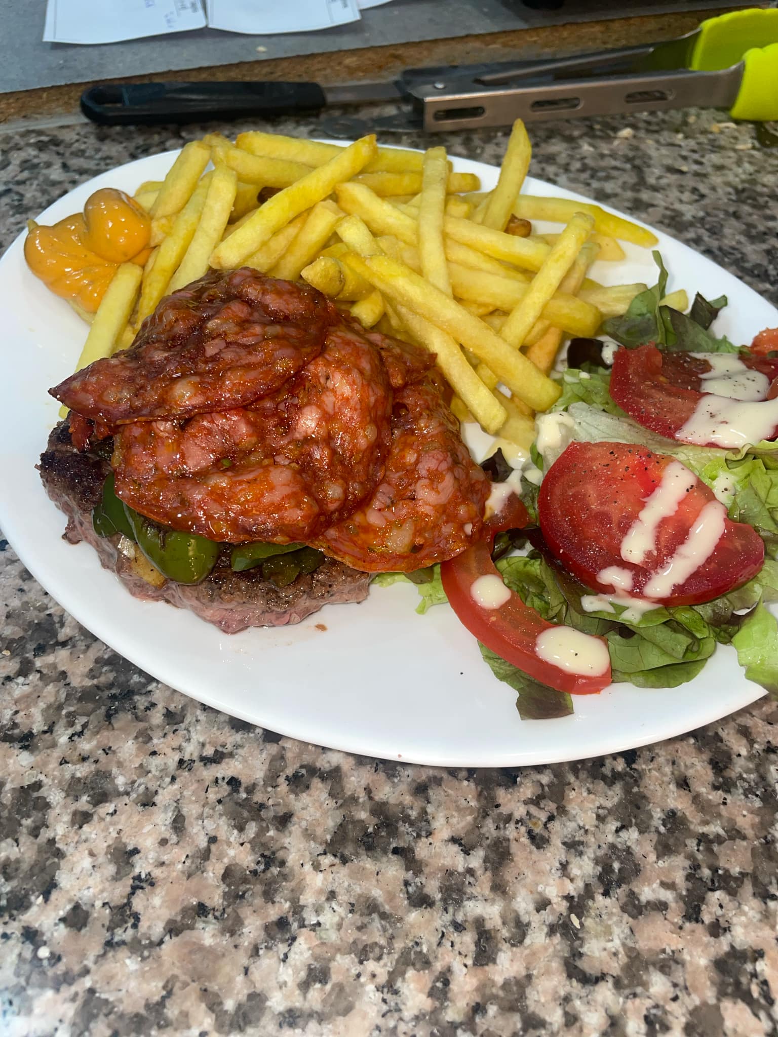 Burger garni de chorizo grillé avec frites dorées et salade fraîche