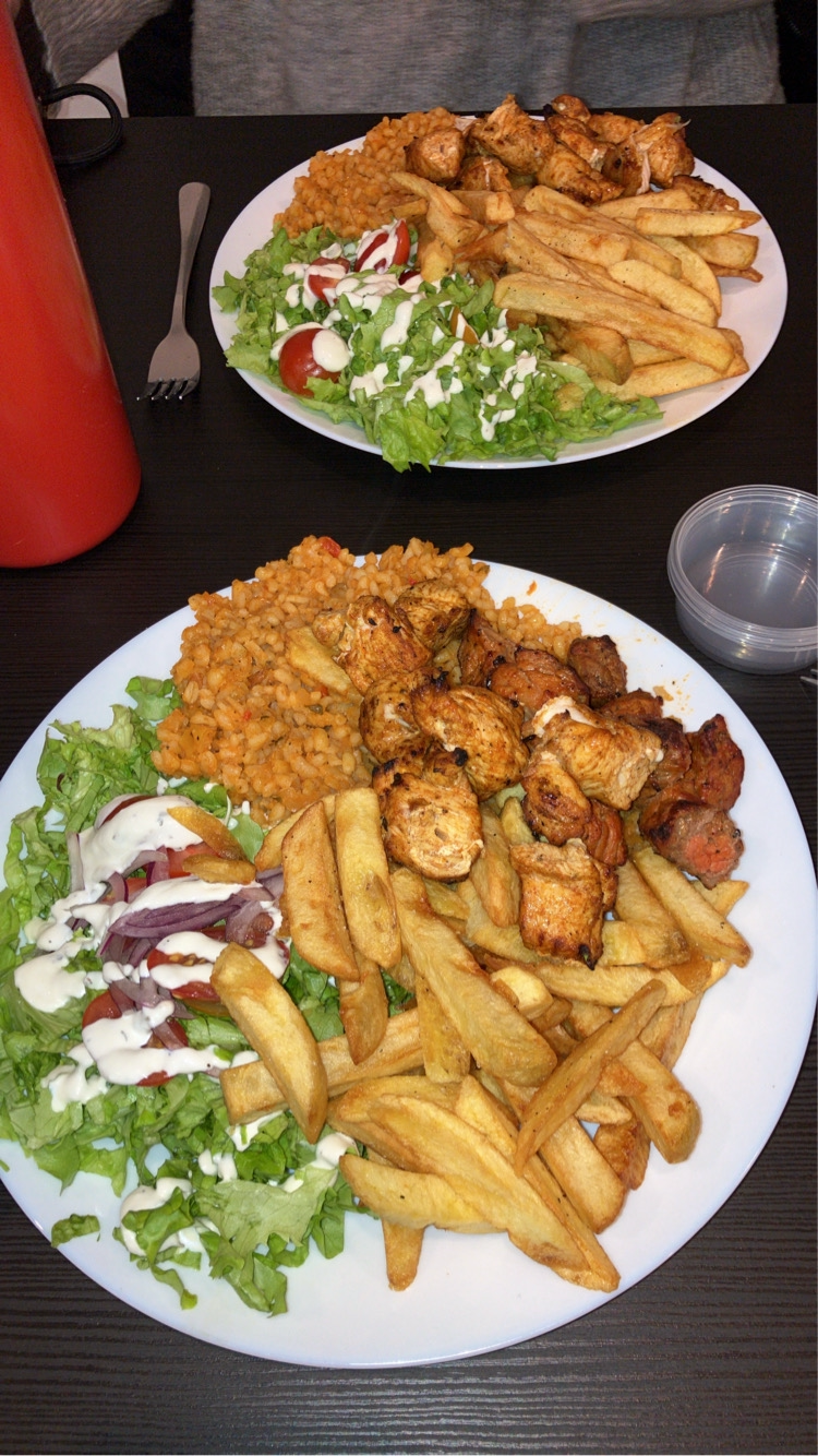 Deux assiettes généreuses avec poulet grillé, boulgour, frites et salade fraîche