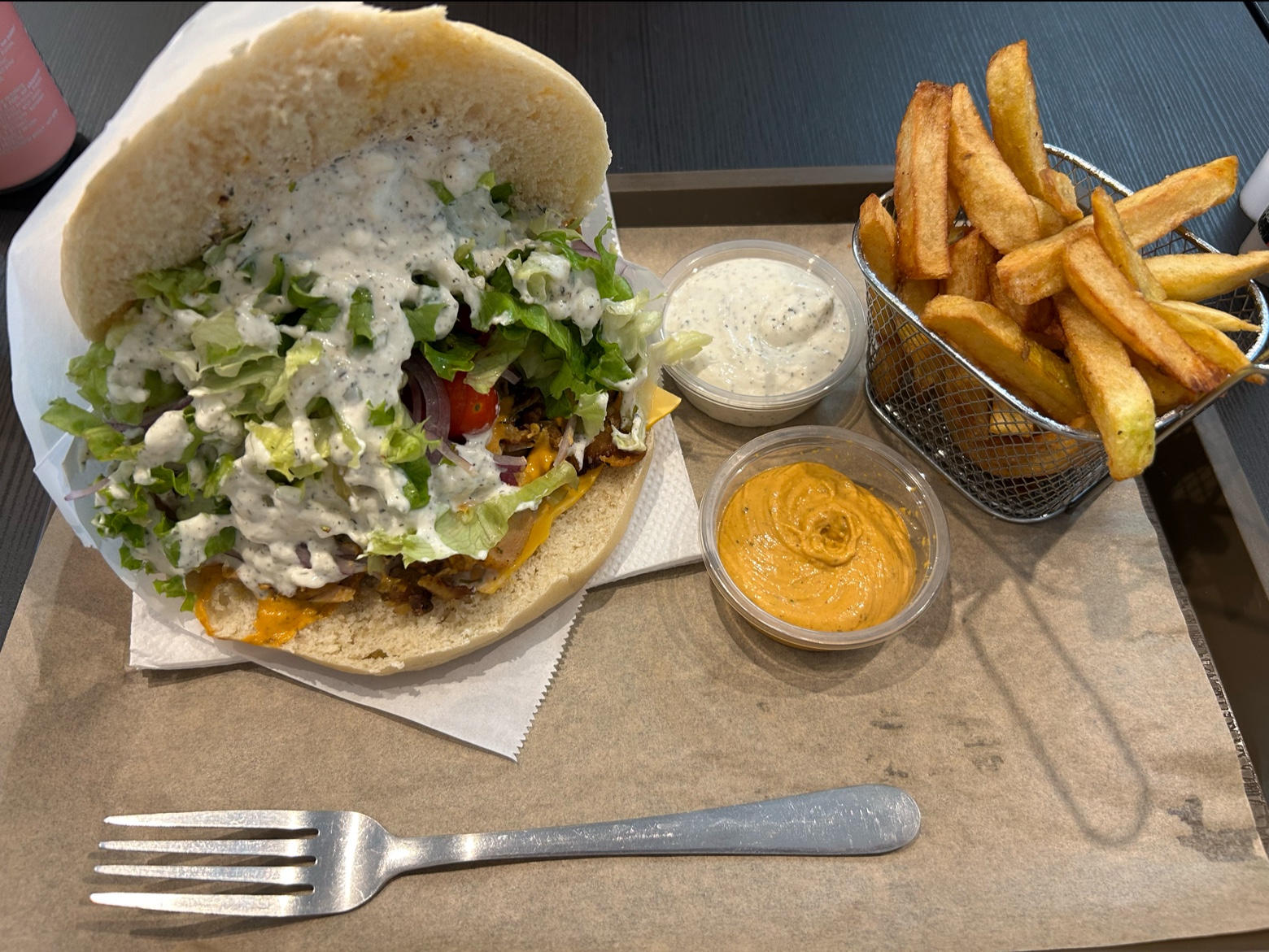 Sandwich kebab garni de viande, salade, sauce blanche et cheddar avec frites croustillantes